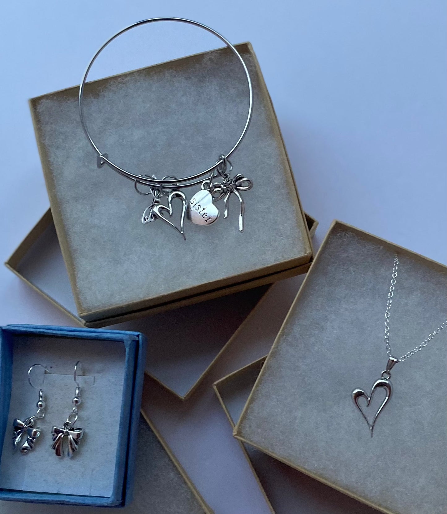 Sister gifts set with heart pendant necklace, bow earrings, and charm bangle bracelet.