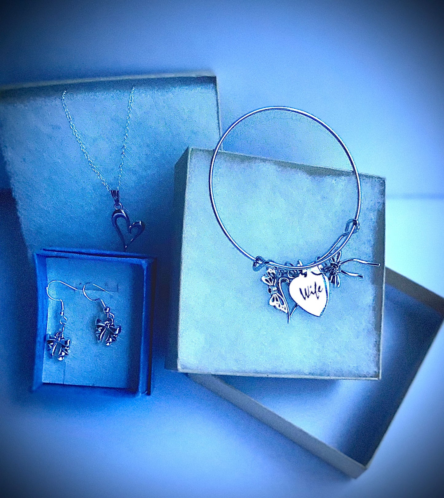 Wife gift set with heart pendant necklace, bow earrings, and charm bangle bracelet.