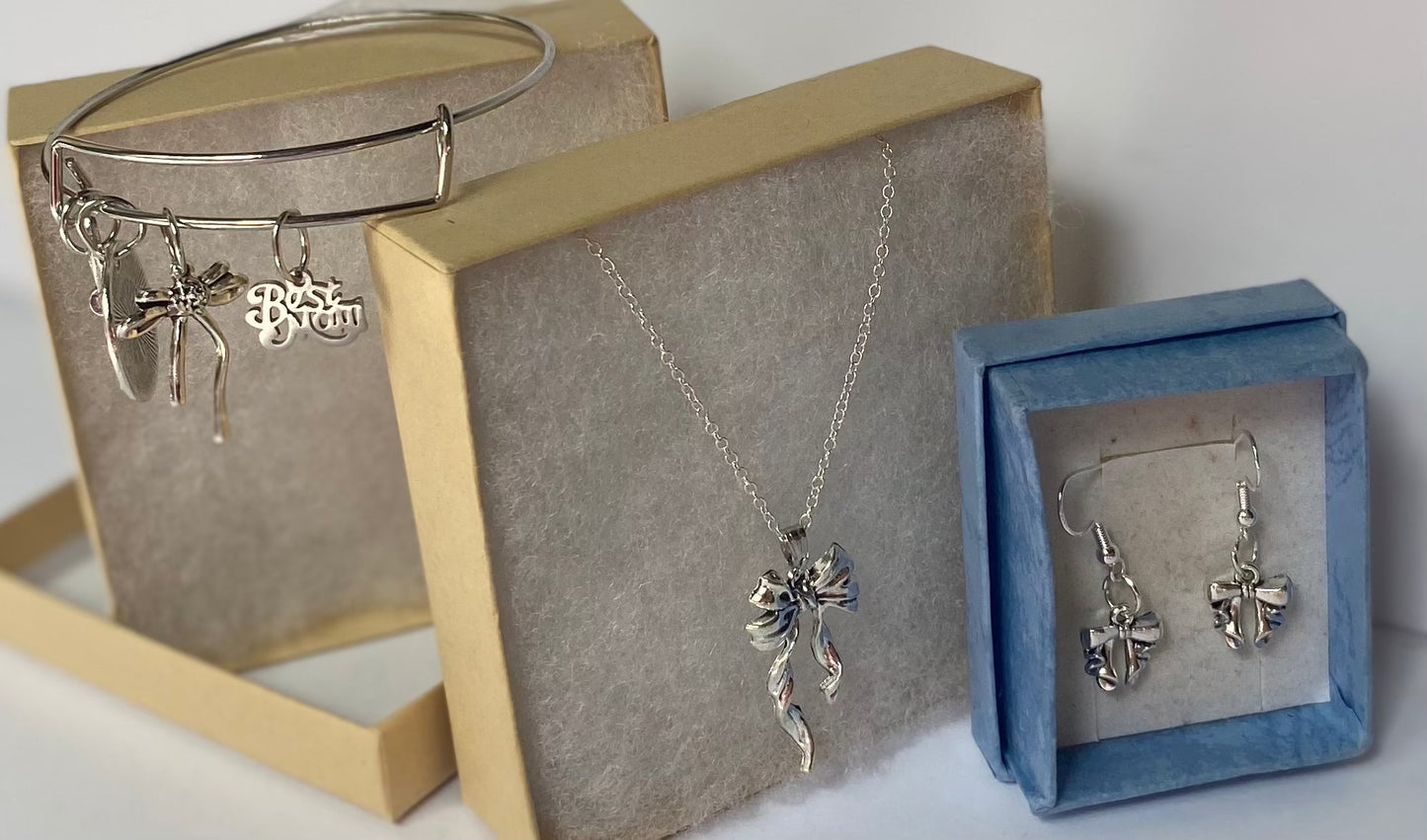 Gift set with heart necklace, bow earrings, and bangle bracelet with charms for mom.